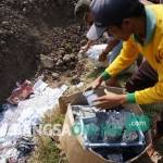 Petugas saat memasukkan ribuan petasan ke kubangan raksasa di TPA Gedangkeret. foto: RONY S/ BANGSAONLINE