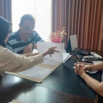 Salah satu pemilik unit di Icon Apartment Gresik saat menandatangani berkas kepemilikan di notaris. Foto: Ist