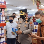 Kapolresta Sidoarjo Kombes Pol. Kusumo Wahyu Bintoro sedang mengecek tanggal kedaluwarsa sebuah produk di salah satu tempat belanja.