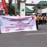 Massa aksi damai bentangkan spanduk di depan kantor Kejari Jombang.