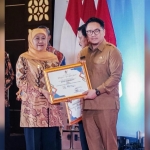 Gubernur Jawa Timur Khofifah Indar Parawansa menyerahkan penghargaan kepada Kepala DPRKPP Kota Surabaya Iman Kristian Maharhandono. Foto: Hms