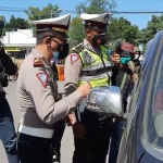 Petugas saat memberhentikan salah satu kendaraan di pos penyekatan Togokan Srengat, Blitar. 