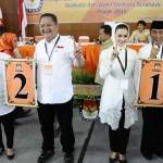 SIMBOL - Paslon Risma-WS dan paslon Rasiyo-Lucy menunjukkan simbol nomor urut yang diperolehnya usai pengundian nomor urut Pilwali Surabaya 2015 di kantor KPU Kota Surabaya, Jumat (25/9). foto: maulana/BANGSAONLINE
