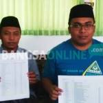 Ketua PC GP Ansor Kabupaten Probolinggo, Muklis, saat menunjukkan bukti kejanggalan proses rekruitmen calon pendamping desa. foto: andi/ BANGSAONLINE
