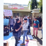 Aksi teatrikal adegan pengereyokan yang diperagakan Wartawan BANGSAONLINE, M. Syuhud Almanfaluty (kanan), dan wartawan MemoX, M. Sugeng, saat demo penolakan RUU Penyiaran di DPRD Gresik. Foto: Ist