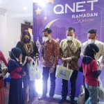 Tim QNET sedang membagikan bingkisan kepada anak-anak yatim.