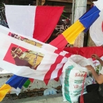 Penjual bendera dan pernak-pernik HUT RI 17 Agustus 2017 tengah menata barang dagangannya. foto: SYUHUD/ BANGSAONLINE