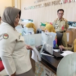 Tampak pegawai Dispendukcapil Batu sedang bercanda dengan pegawai lainnya. Layanan tatap muka seperti ini tetap dibuka untuk kepentingan urgen saja.