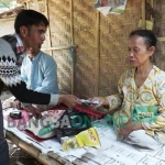 Ketua Forum Silaturrahmi Wartawan Harian (Rumah Satu) Situbondo, Zaini Zen, saat memberikan bantuan sembako dan uang kepada Ibu Ima di Desa Peleyan Kecamatan Kapongan Situbondo. foto: MURSIDI/ BANGSAONLINE