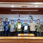 Direktur Utama PJT I, Raymond Valiant Ruritan (tengah memakai kemeja batik biru) bersama Direktur Utama PT KTI, Agus Nizar Vidiansyah (memakai kemeja batik hijau) usai melakukan penandatanganan kerja sama pengembangan layanan air bersih.