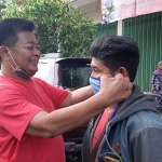 De Anwar sedang memakaikan masker ke salah satu warga.