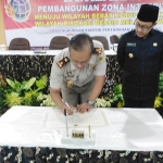 Masduki saat menandatangani piagam deklarasi zona bebas korupsi di kawasan BPN Kota Malang, disaksikan Wali Kota Malang Sutiaji, Polres Makota, Kejaksaan Negeri Kota Malang, Kodim 0833, dan Tim Saber Pungli, Selasa (08/01). Foto: IWAN IRAWAN/BANGSAONLINE