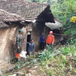 Petugas Polsek dan Koramil Pulung dibantu BPBD Ponorogo saat membersihkan material longsor yang menimpa rumah Marni, warga Desa Wagir Kidul, Kecamatan Pulung.