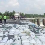 Tumpukan sak limbah yang digunakan untuk menahan tanggul sungai. foto: ROMZA/ BANGSAONLINE