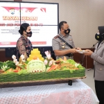 Kapolres Kediri AKBP Lukman Cahyono saat menyerahkan potongan nasi tumpeng kepada polwan senior Aiptu Lilis Budiarti. (foto: ist)