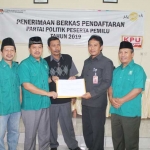 Ketua DPC PKB Nganjuk Ulum Bastomi saat menerima bukti tanda terima berkas pendaftrana dari Komisioner KPU Nganjuk Divisi Hukum Yudha Hernanto (dua dari kanan). Foto: BAMBANG D J/BANGSAONLINE