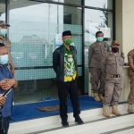 Hasbullah (memakai jaket hitam) saat akan menyampaikan permintaan maaf di hadapan para wartawan. foto: bangsaonline.com