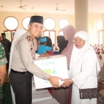 Kapolres AKPB Wahyu Sri Bintoro saat memberikan bingkisan kepada anak yatim piatu dan janda.  foto: SYUHUD/ BANGSAONLINE