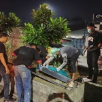 Petugas saat mengevakuasi pria yang diduga seorang tunawisma dan ODGJ di taman pembatas jalan di dekat pintu keluar JPO Terminal Purabaya, Minggu (6/5/2024).