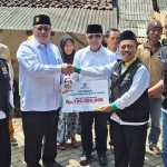 Penyerahan bantuan oleh Wakil Ketua II Baznas Jatim, KH Ahsanul Haq, kepada Ketua Baznas Banyuwangi, H Lukman Hakim, disaksikan Asisten Pemerintahan Pemkab Banyuwangi. Foto: Ist