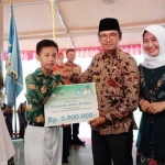 Bupati Bangkalan R. Abdul Latif dan Ketua PKK Zainab Zuraidah saat memberikan beasiswa kepada siswa berprestasi di Pendopo Agung Bangkalan.