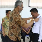 Kadispol PP Gresik Darmawan bersama Bupati Sambari saat memasang id card kepada anggota Satpol yang lulus uji kompetensi. foto: SYUHUD/ BANGSAONLINE