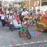 Anak-anak Perumahan Kembangan memamerkan sepedanya yang sudah dihias dalam lomba peringatan HUT Kemerdekaan RI ke-74 tahun 2018. foto: SYUHUD/ BANGSAONLINE