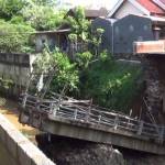 Jembatan yang putus akibat derasnya arus sungai. foto : arif kurniawan/ BANGSAONLINE