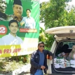 Pendiri RGS Indonesia Moh Khozin dengan latar belakang tumpukan kaos RGS Prabowo-Gibran di mobil untuk dibagikan kepada masyarakat. Foto: Ist.

