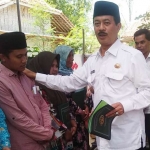 Pj Bupati Pamekasan Fattah Jasin ketika menyerahkan sertifikat yang sudah jadi pada warga Pamekasan.