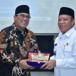 Bupati Muara Enim, Ahmad Yani saat menyerahkan cinderamata pada Bupati Fadeli.
