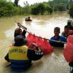 Tim tanggap darurat Dinsos dan BPBD membantu mengevakasi dan memberikan nasi bungkus kepada korban banjir. foto: bahri/ BANGSAONLINE