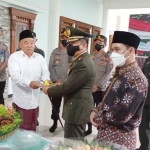 Kiai Asep memotong tumpeng lalu diberikan kepada Dandim 0815 Mojokerto.