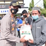 Kapolres Lamongan AKBP Harun saat menyerahkan bantuan sembako kepada warga terdampak Covid-19. (foto: ist)