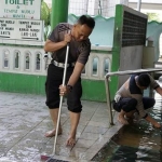 Kanit Turjawali Iptu Yusuf dan anggota Unit Kamsel saat membersihkan tempat wudhu. Foto: M. ANDY FACHRUDIN/ BANGSAONLINE