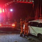 Petugas saat mengevakuasi kendaraan yang terlibat kecelakaan tunggal di Jalan Manyar Kertoarjo, Surabaya.