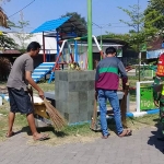 Para pelanggar protokol kesehatan saat membersihkan sarana fasilitas umum. (foto: ARDIANZAH/ BANGSAONLINE)