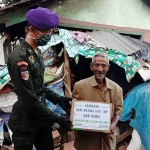 Personel Menwa 836/MP Unisma saat membagikan bantuan paket sembako kepada salah satu warga.