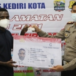 Kasatlantas Polres Kediri Kota AKP Arpan saat menyerahkan SIM C kepada salah satu mahasiswa asal Papua. foto: ist.