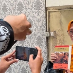 Asfinwati, ibu Faiz saat menunjukkan sebuah buku kepada wartawan. Foto: Ist