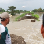 Bupati Gresik Fandi Akhmad Yani (topi abu-abu) turun langsung melihat kondisi tanggul Anak Kali Lamong di Desa Cermen, Kecamatan Kedamean yang jebol. Foto: SYUHUD/ BANGSAONLINE
