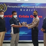 Kasubbag Humas Polres Kediri Kota Kompol Kamsudi saat menyerahkan kue ulang tahun kepada Ketua PWI Kediri Mega Wulandari. (foto: MUJI HARJITA/ BANGSAONLINE)