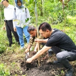 CEO Kencana Grub, Hendry Setiawan (kanan) menanam bibit pohon didampingi Pembina Yayasan Grojokan Sewu di kaki Gunung Welirang.
