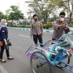 Iptu Suyitno, Kasat Binmas Polres Bangkalan saat memberikan takjil di Jl. Soekarno Hatta Bangkalan. (foto: ist)