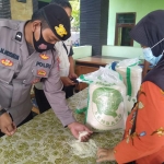 Petugas kecamatan dan agen mengecek kualitas beras sebelum disalurkan.