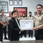Kabid Humas Polda Jatim saat menerima penghargaan 