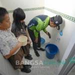 Bupati Jombang dan murid SD Wijana sedang memeriksa air dikamar mandi apakah ada jentik nyamuk atau tidak. foto: rony suhartomo/bangsaonline