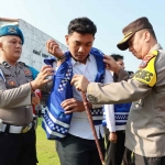 Kapolres Mojokerto Kota, AKBP Wiwit Adisatria saat memberikan secara simbolis rompi Polisi RW kepada salah satu personelnya, Senin (15/5/2023).