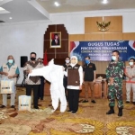 Gubernur Jawa Timur Khofifah Indar Parawansa saat mendistribusikan secara simbolik paket alat medis  pada Minggu (10/5) malam di Gedung Negara Grahadi Surabaya. Foto: ist/bangsaonline.com