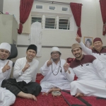 KH Ahmad Muzakki Syah (berkalung tasbih, nomor 3 dari kiri) mengacungkan salam satu jari bersama Emil Elestianto Dardak (nomor 2 dari kiri) dan Ra Fadil (nomor 1 paling kiri), putera Kiai Ahmad Muzakki Syah. Foto: bangsaonline.com